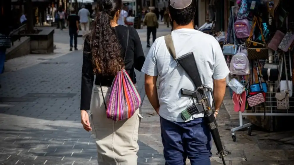 An Israeli carries an M16 assault rifle in downtown Jerusalem, Nov. 5, 2023. Photo by Nati Shohat/Flash90.