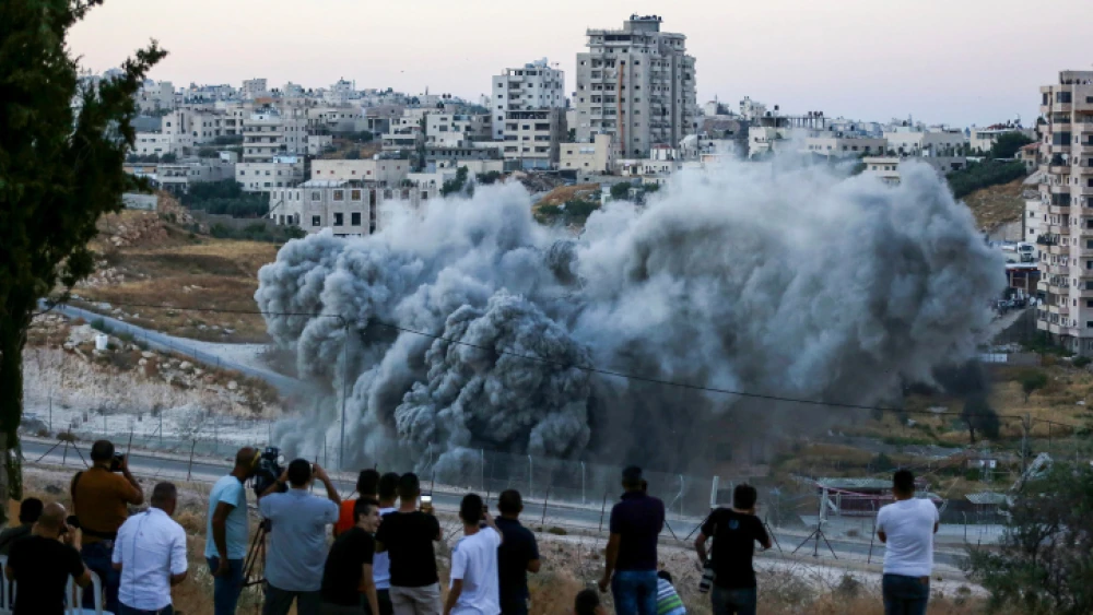 An illegally constructed building in Sur Baher along the security fence in eastern Jerusalem is blown up by Israeli forces on July 22, 2019. Photo by Wisam Hashlamoun/Flash90.