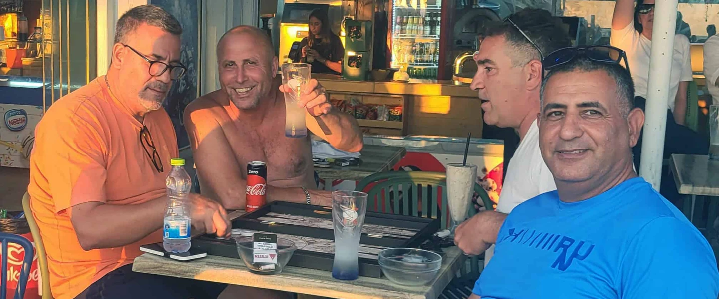 Ron Hazan raises a glass with friends at Moshav Shavei Tzion in the Western Galilee on June 24, 2025. Photo by Canaan Lidor.