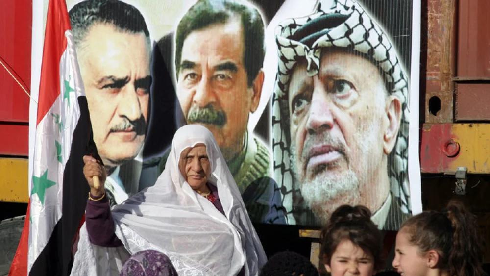 Palestinians commemorate the third anniversary of the death of Saddam Hussein during a rally in the town of Halhoul near Hebron on Jan. 15, 2010. Next to the picture of Hussein (center) is a photo of late Palestinian leader Yasser Arafat. Credit: Najeh Hashlamoun/Flash90.