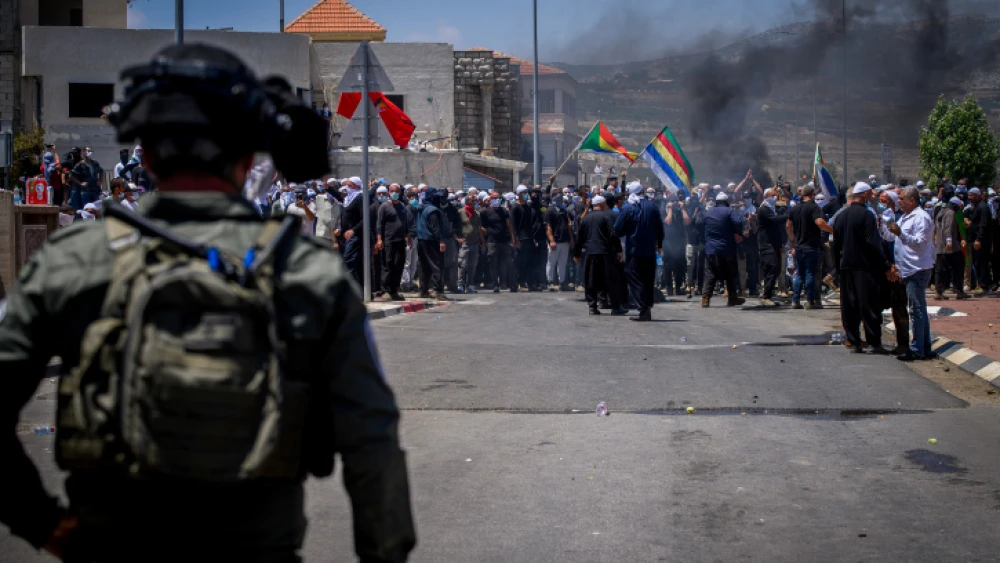 Druze protest while police guard during a protest against the construction of a new wind farm in the Druze village of Mas'ada, in the Golan Heights, June 21, 2023. Photo by Ayal Margolin/Flash90 *** Local Caption *** ???? ???????? ????? ?????? ??????? ????? ???? ??