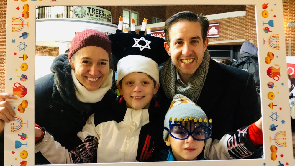 Allison Aboud Holzer of West Hartford, Conn., husband Paul, and sons Adrian and Isaac, prepare to celebrate Hanukkah. Credit: Courtesy.
