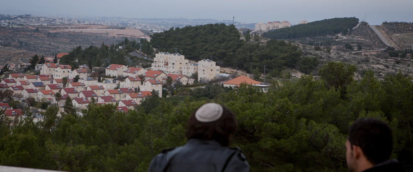 A Jewish man and a Palestinian man take in views of the Jewish town of Efrat (foreground) and the Palestinian city of Bethlehem (background) on Dec. 17, 2014. Photo by Miriam Alster/Flash90.
