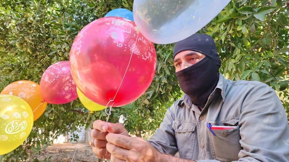 Masked terrorists prepare helium balloons with incendiary material to be flown into Israel, aiming to cause casualties and damage, on Sep. 22, 2023. Photo by Majdi Fathi/TPS.