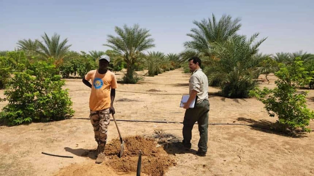 A member of the Keren Kayemeth LeIsrael delegation speak with a Chadian, August 2023. Credit: KKL-JNF.