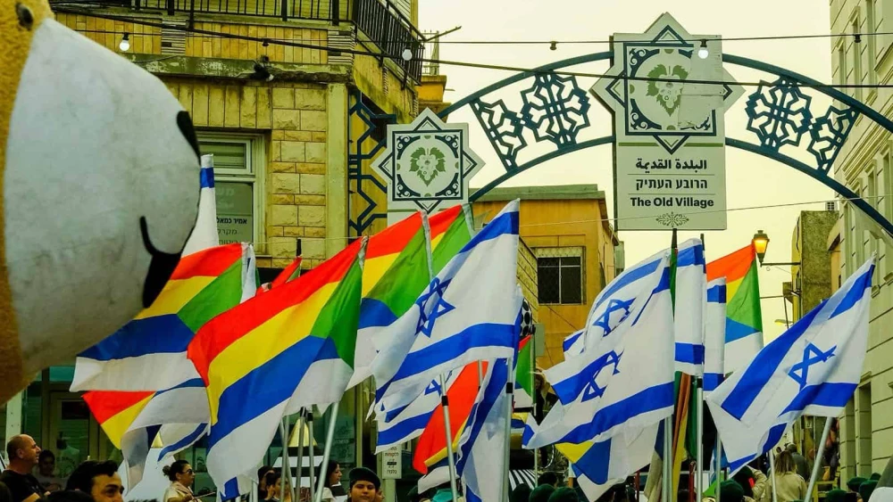 Druze and Israeli flags are raised as Syrian Druze leaders visit the Israeli Druze town of Daliyat al-Karmel during the festival of Nabi Shuaib on April 25, 2025. Photo by Rabia Basha.