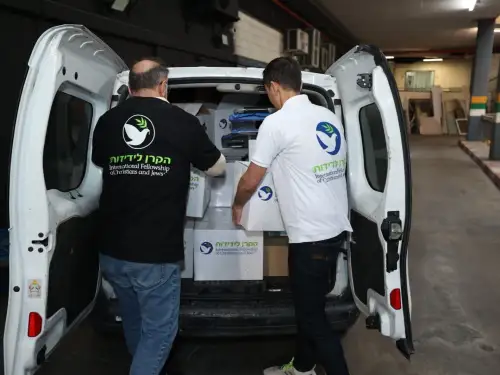 International Fellowship of Christians and Jews' (IFCJ) volunteers removing packages from a van. Photo by Elad Zagman/IFCJ.
