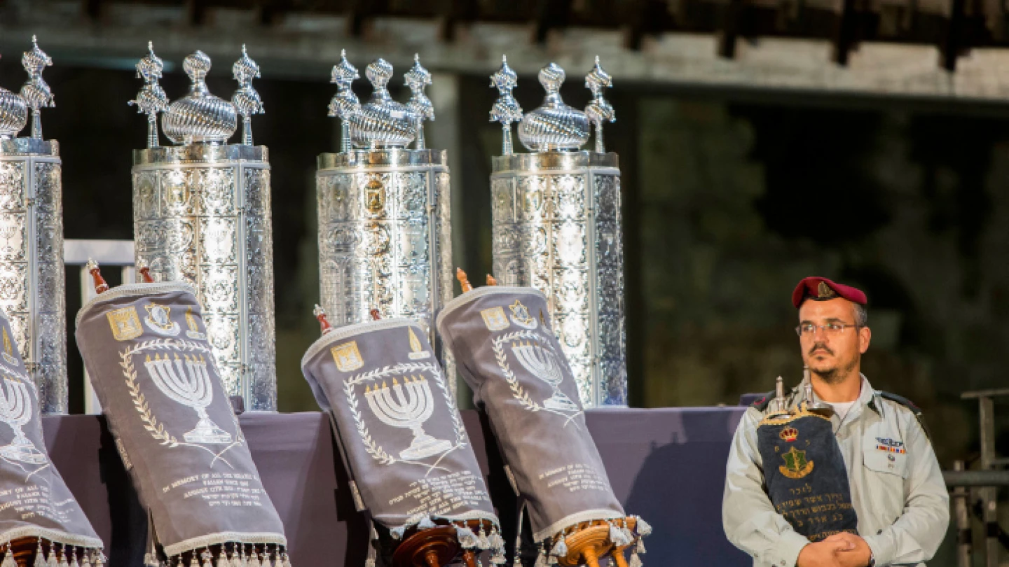 An Israeli soldier holds the Torah Scroll carried by IDF Chief Rabbi Shlomo Goren in the Six-Day War, during a ceremony at the Western Wall in Jerusalem, in memory of the soldiers killed in "Operation Protective Edge" and in Israel's other wars. Aug.12, 2015. Photo by Yonatan Sindel/Flash90.