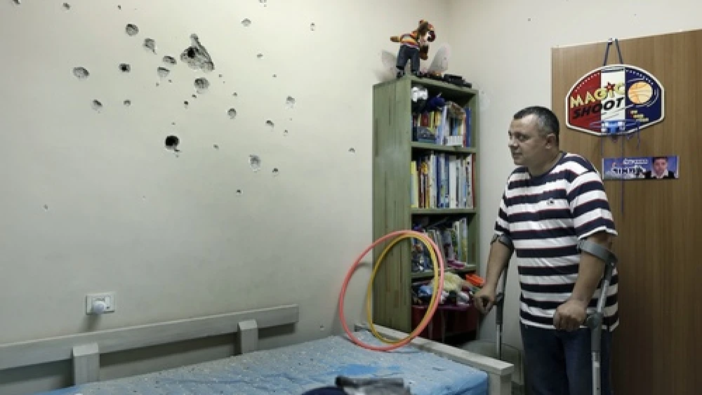 An Israeli man examine the damages from the shrapnel in a child's room after a long-range Grad rocket fired by Palestinian terrorists from the Gaza Strip landed in the backyard of a house in the southern Israeli town of Netivot, Friday, Oct. 12, 2012. Credit: Tsafrir Abayov/Flash90.
