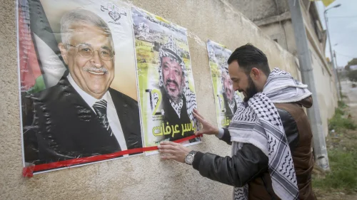 Palestinians hang posters depicting the late Palestinian chief Yasser Arafat and the current Palestinian leader Mahmoud Abbas in the West Bank city of Nablus, March 14, 2017. Photo by Nasser Ishtayeh/Flash90.