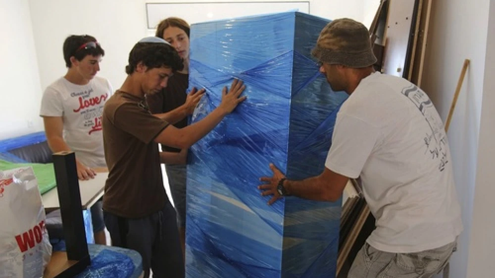 Click photo to download. Caption: Former Jewish residents of Migron, assisted by volunteers, move in to their new home of Givat Hayekev. Credit: Oren Nahshon/FLASH90.