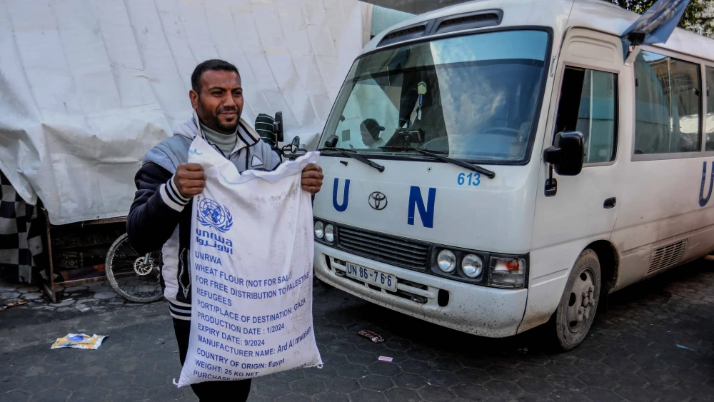 A Palestinian receives food at an UNRWA school in Rafah, the southern Gaza Strip, Jan. 28, 2024. Photo by Abed Rahim Khatib/Flash90.