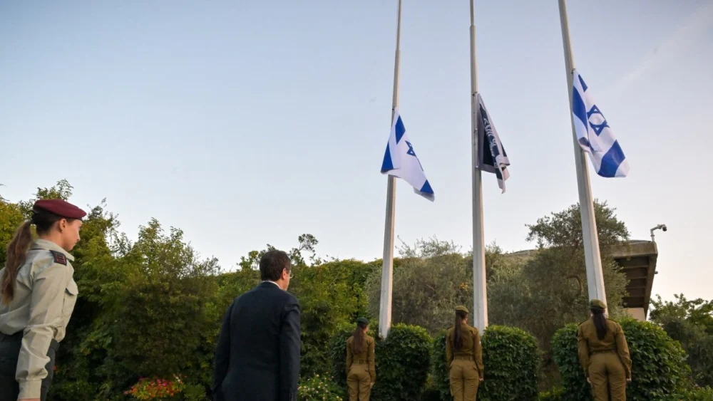 Israeli President Isaac Herzog watches as Israeli flags are lowered to half-staff at 6:29 a.m. at the President’s Residence in Jerusalem on Oct. 5, 2026, marking the national day of remembrance for the Oct. 7, 2023, terror attacks and the Swords of Iron war. Credit: Spokesperson of the Office of the President.