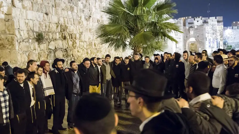 A group of students and rabbis sing “Acheinu” at the site outside the Jaffa Gate in Jerusalem where Rabbi Reuven Biermacher, 45, a husband and father of seven, was stabbed and killed by Palestinian terrorists on Dec. 23, 2015. Credit: Aish HaTorah.