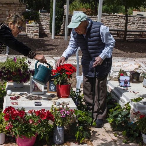 Yaakov Lubinewski, 99, tends the graves of two Israeli soldiers from his town killed during Hamas's Oct. 7 massacre, March 26, 2024. Credit: Rina Castelnuovo.