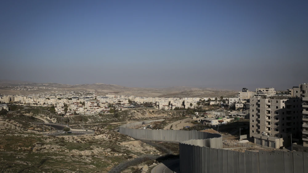 The separation wall runs along the Palestinian refugee camp, Shuafat, separating it from the Jewish town of Pisgat Ze'ev, near Jerusalem, on Jan. 29, 2014. Photo by Hadas Parush/Flash 90.