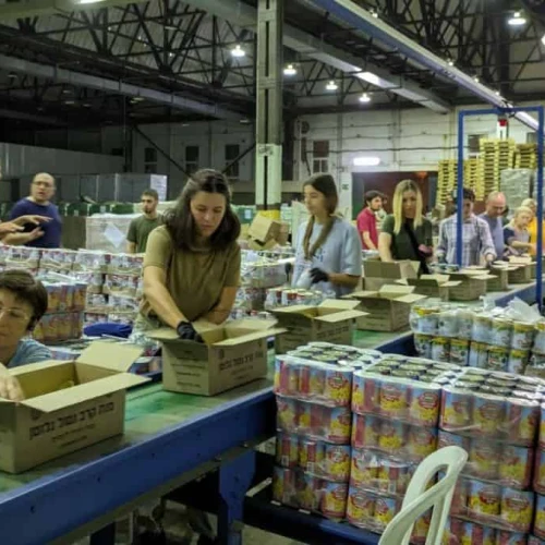 Immigrants from Russia and Ukraine pack food at an Israeli army base. Photo by Shishi Shabbat Yisrael.