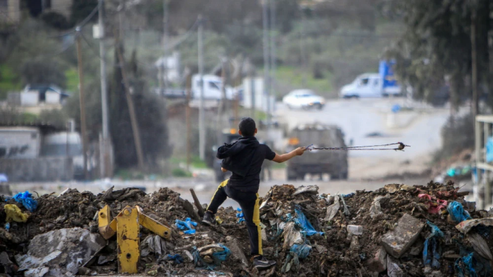 A Palestinian boy readies to throw a stone at Israeli security forces during a protest in the village of Beita, near the city of Nablus, Jan. 28, 2023. Credit: Nasser Ishtayeh/Flash90.