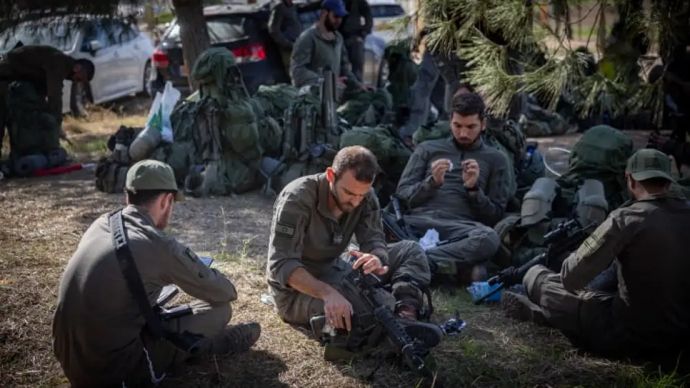 Israeli soldiers take a break before entering the Gaza Strip, Dec. 20, 2023. Photo by Yonatan Sindel/Flash90.