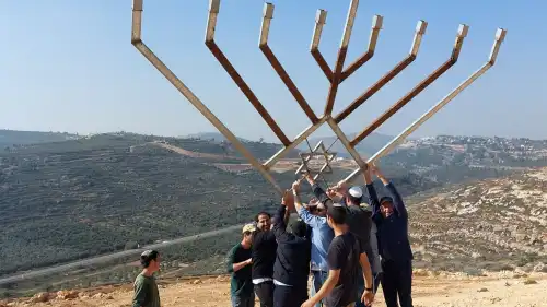 A delegation from Great Neck, N.Y., joins local youth to raise a large Chanukah menorah over the Shiloh Valley in Israel on Dec. 9, 2022. Credit: Courtesy of the Heartland Initiative.