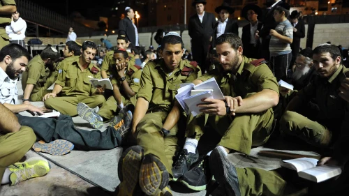 IDF soldiers sit on the ground during Tisha B'Av prayers at the Western Wall in the Old City of Jerusalem, July 16, 2013. Photo by Mendy Hechtman/Flash90.