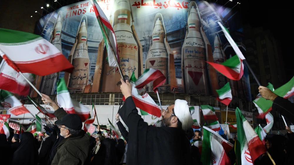 Pro-regime activists gather in Tehran's Vali Asr Square under a banner depicting Iran's ballistic missile arsenal, March 17, 2026. Photo by Kaveh Kazemi/Getty Images.