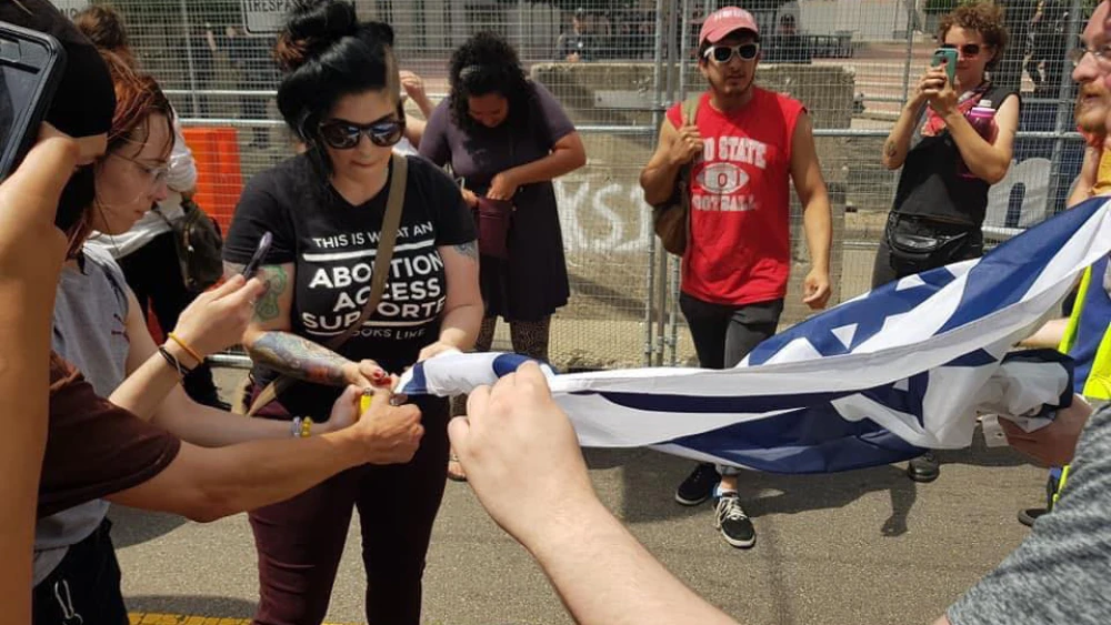 Counter-protesters attempt to set an Israeli flag on fire near a Ku Klux Klan rally at Dayton’s Courthouse Square, May 25, 2019. Photo by Corine Fairbanks.