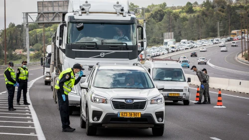 An Israeli police officer at a temporary coronavirus “checkpoint“ on Highway 1 outside of Jerusalem. Photo by Nati Shohat/Flash90.