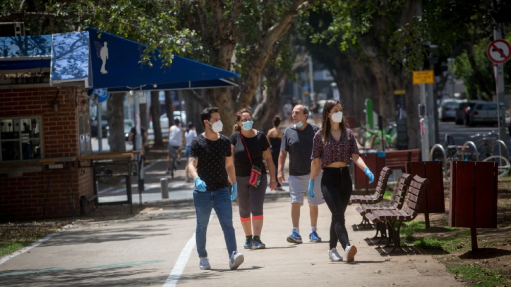 Pedestrians in Israel wear face masks, which are mandated by the Health Ministry as a preventative measure against the spread of coronavirus (COVID-19), on Rothschild Boulevard in Tel Aviv, April 22, 2020. Photo by Miriam Alster/Flash90.