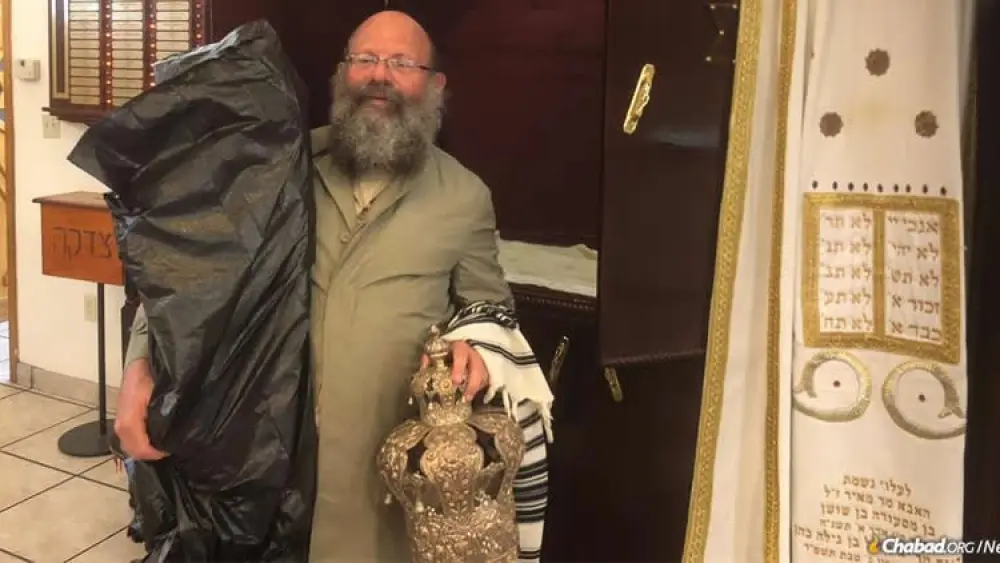 Rabbi Doron Aizenman evacuates Torah scrolls from the Myrtle Beach Chabad synagogue. Credit: Chabad.org/News.