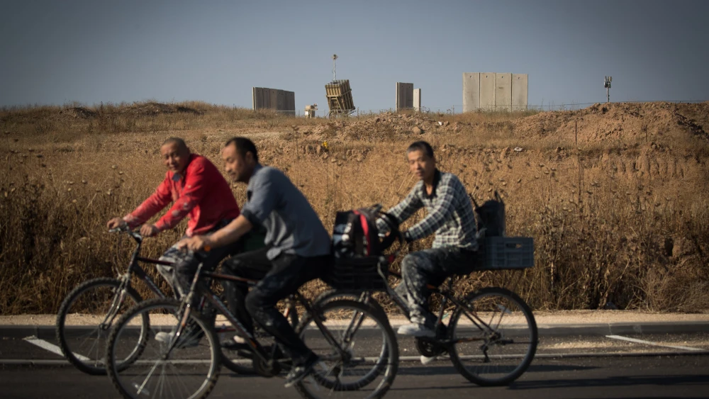 People ride bicycles near an Iron Dome anti-missile battery near the city of Sderot in southern Israel, May 29, 2018. Credit: Yonatan Sindel/Flash90