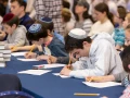 Students write feverishly at Chidon HaTanakh at Manhattan Day School. Photo by David Khabinsky.
