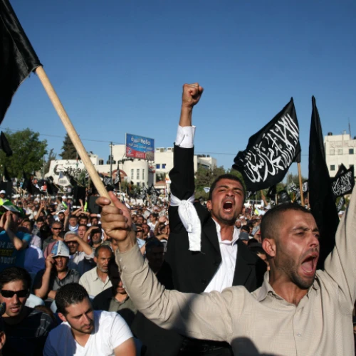 Palestinian supporters of Hizb ut-Tahrir, or the Islamic Liberation Party, chant slogans and wave black and white flags reading "There is no God but God, and Muhammad is his prophet" during a rally in Ramallah on July 7, 2012. Photo by Issam Rimawi/Flash90.
