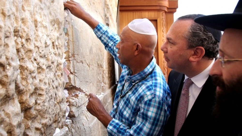 Hip-hop mogul Russell Simmons places a note in the Western Wall during his recent trip to Israel. Behind him is his partner for Muslim-Jewish dialogue work, New York Rabbi Marc Schneier. Photo by Sasson Tiram.