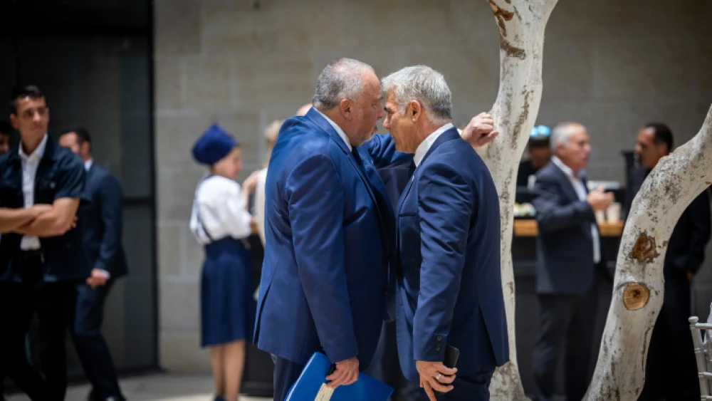 Now-former Finance Minister Avigdor Liberman and then-Foreign Minister Yair Lapid greet at a conference at the Givat Ram campus of the Hebrew University in Jerusalem, May 29, 2022. Photo by Yonatan Sindel/Flash90.