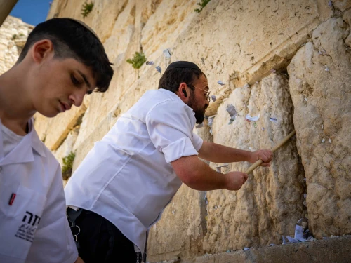 Workers remove handwritten notes placed between the ancient stones of the Western Wall in the Old City of Jerusalem, April 2, 2025. Photo by Yonatan Sindel/Flash90.