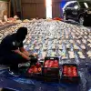 A Saudi customs officer opens imported pomegranates, used to smuggle millions of Captagon pills from Lebanon, at Jiddah Islamic Port, Saudi Arabia, April 23, 2021. Credit: AP via Saudi Press Agency.