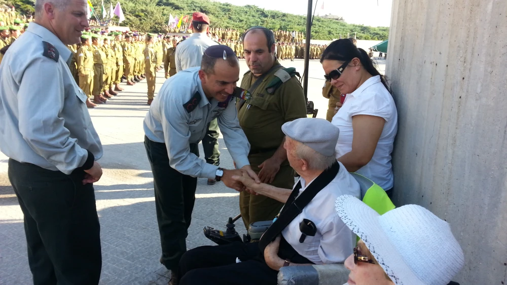 Holocaust survivors Edith and Joel Sykora, who were watching the ceremony at Latrun’s Armored Corps Memorial from their wheelchairs, were being given a mazel tov by all the Israel Defense Forces’ brass as they walked towards the dais. Credit: Courtesy of Sykora family.