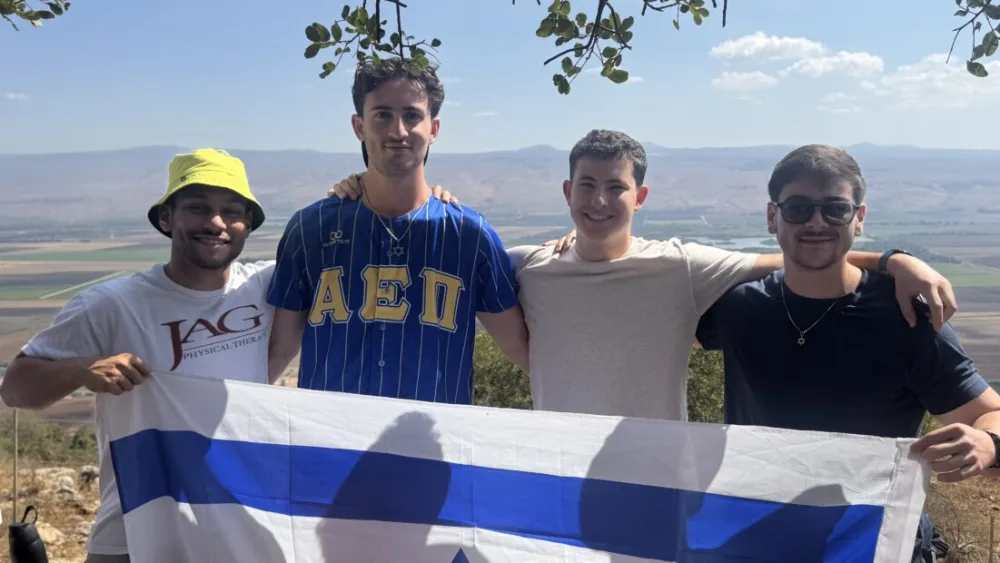 Four members of the AEPi fraternity with an Israeli flag. Courtesy: AEPi.