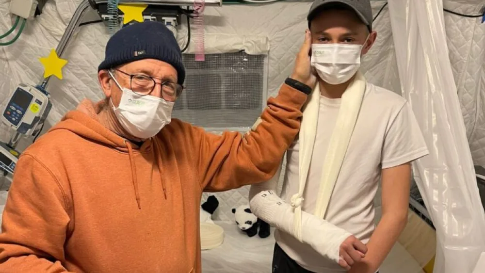 Orthopedist Dr. Elhanan Bar-On, medical director of Israel’s Shining Star field hospital in Ukraine, with a 14-year-old he treated for a broken arm. Photo by Naama Frank Azriel.