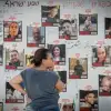 A woman looks at photographs of Israelis held by Hamas in Gaza, at "Hostage Square" outside the Tel Aviv Museum of Art, Oct. 30, 2023. Photo by Miriam Alster/Flash90.