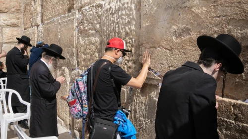 An American tourist wearing a face mask for fear of the coronavirus prays at the Western Wall in the Old City of Jerusalem on Feb. 27, 2020. Photo by Olivier Fitoussi/Flash90.