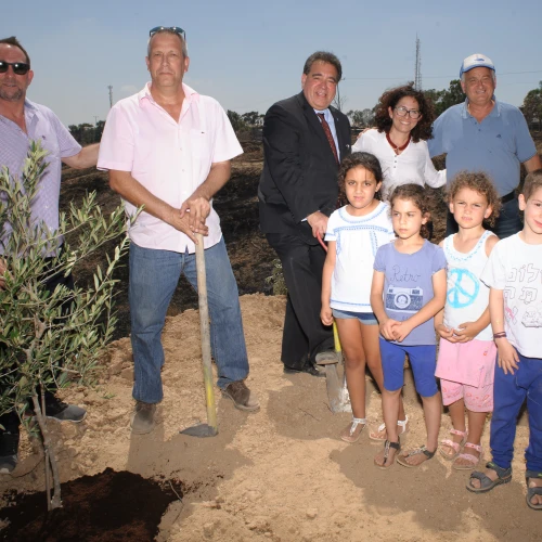 From left: Ron Werner, Mayor Gadi Yarkoni, CEO of JNF-USA Russell Robinson, Michal Uziyahu, Alon Shuster and kids in Eshkol plant an olive tree in the burnt ground where an incendiary kite from Gaza had destroyed all vegetation. Credit: Courtesy.