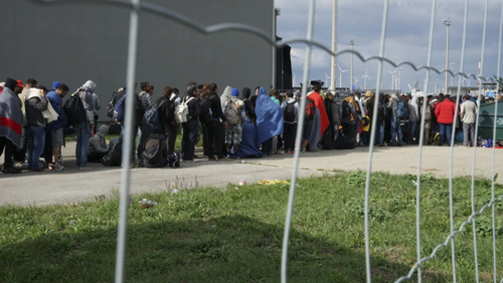Syrian refugees wait in line to cross the border of Hungary and Austria on their way to Germany in September 2015. Credit: Mstyslav Chernov via Wikimedia Commons.