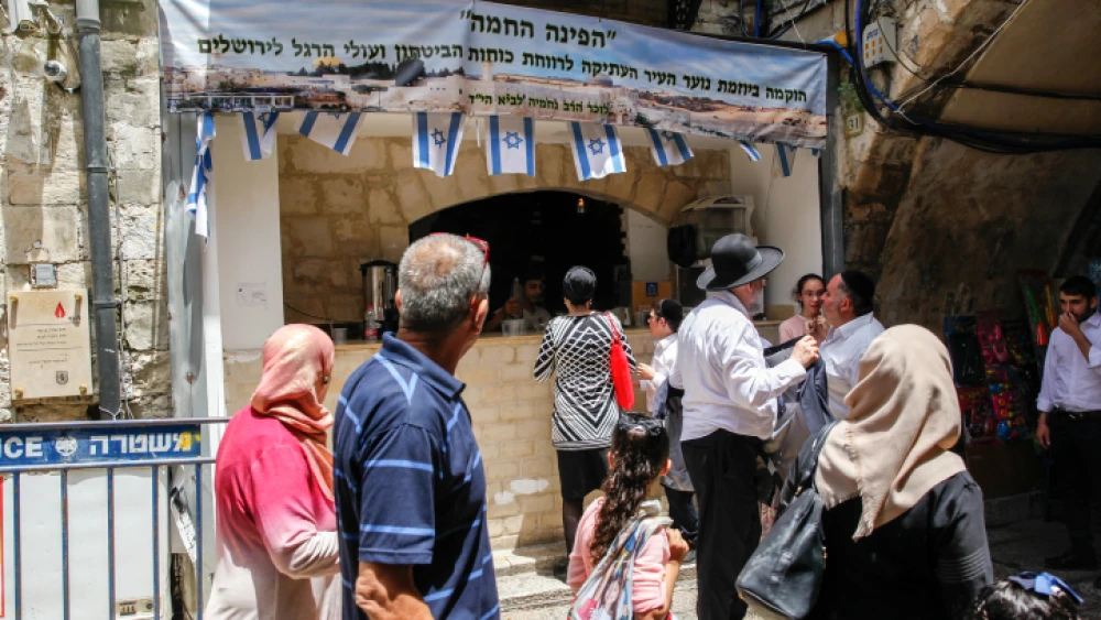 Muslims walk near a shop belongs to Israelis during Ramadan in the Muslim Quarter of Jerusalem's Old City on May 20, 2018. Photo by Sliman Khader/Flash90.