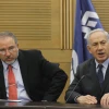 Israeli Prime Minister Benjamin Netanyahu (right) and then Foreign Minister Avigdor Lieberman at a meeting of the Likud-Beiteinu faction in the Knesset on March 11, 2014.