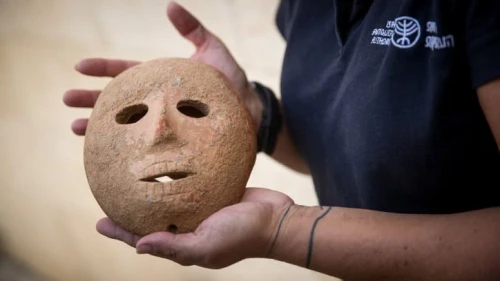 Ronit Lupo of the Israel Antiquities Authority holds a 9,000-year-old stone mask recovered from thieves by the Antiquities Authority Theft Prevention Unit in southern Hebron Hills, during a press conference in Jerusalem on Nov. 28, 2018. Photo by Yonatan Sindel/Flash90.
