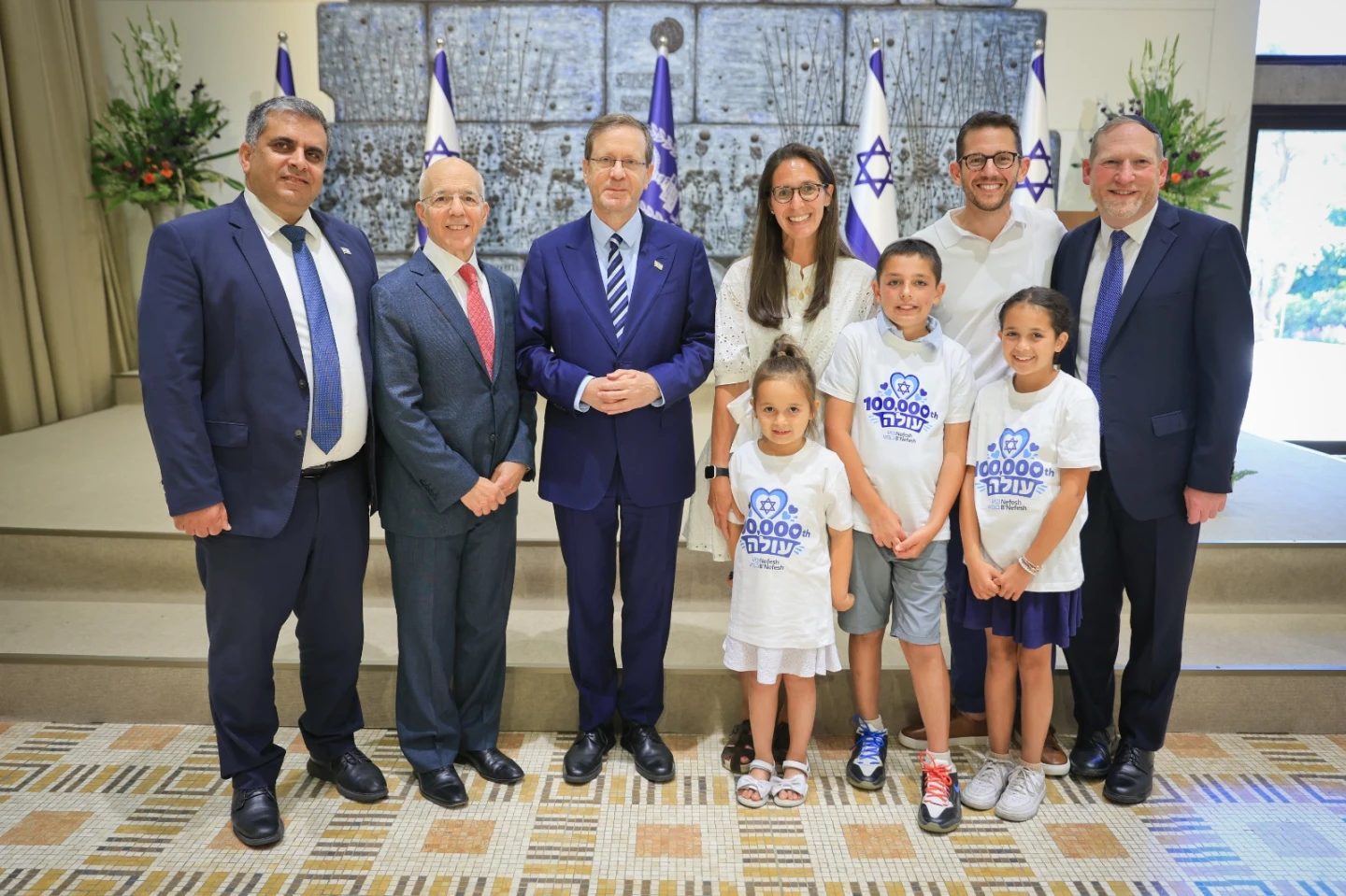 President Isaac Herzog, Aliyah and Integration Minister Ofir Sofer, and Nefesh B'Nefesh founders Rabbi Yehoshua Fass and Tony Gelbart welcome Atara and Jeffrey Douglas (in white shirts) and their children, Emilia, 6, Nathaniel, 10, and Hallie, 9, at the President’s Residence in Jerusalem on Aug. 9, 2026. Photo by Yonit Schiller/Nefesh B'Nefesh.