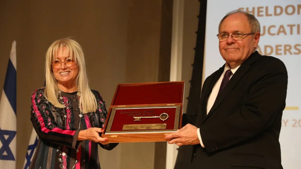 Dr. Miriam Adelson is presented with a key by Yad Vashem director Dani Dayan. Credit: Yad Vashem.