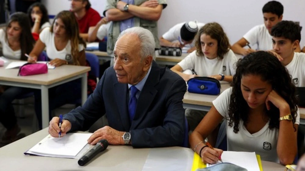 Israeli President Shimon Peres sits with first-graders on the first day of school in the Sha'ar Hanegev area in southern Israel, the same day a Qassam rocket was fired into the area from the Gaza Strip. Photo by Edi Israel/Flash90.